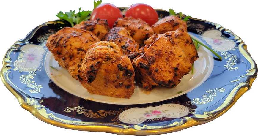 Plated grilled chicken with tomatoes and parsley.